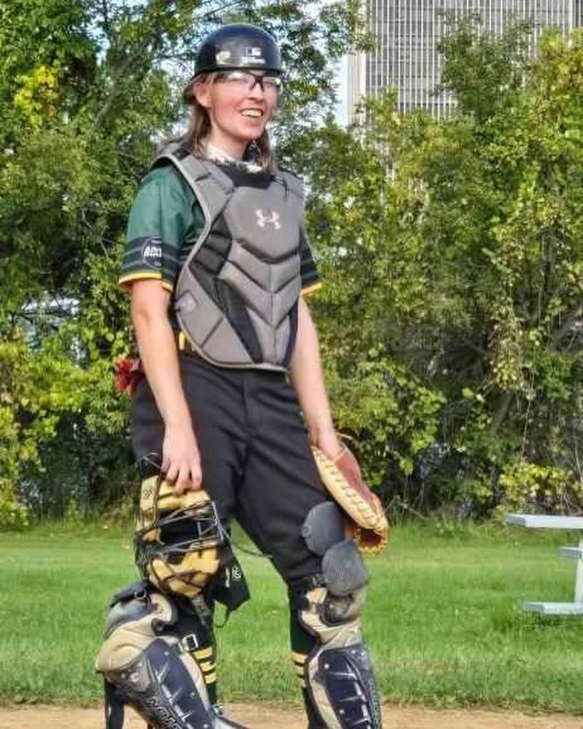 Rand, smiling, adorning catching gear at "Ant Field" during an open scrimmage.